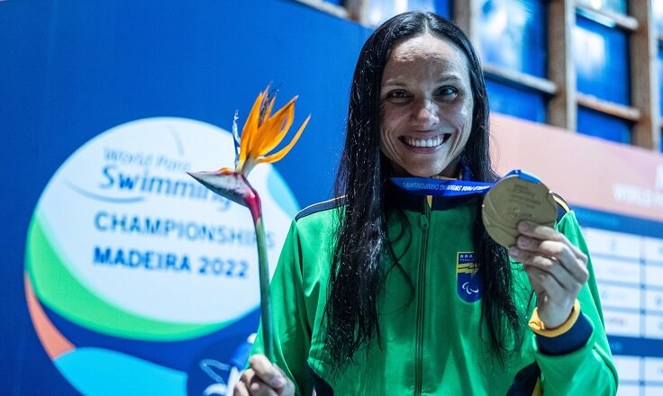Atleta Maria Carolina Gomes levantando medalha.