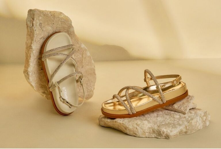 sandalia dourada sobre pedra branca