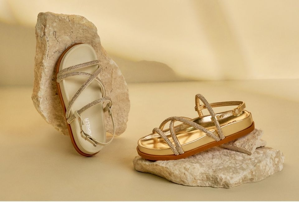 sandalia dourada sobre pedra branca